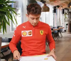 Charles Leclerc Holds Up Sign   