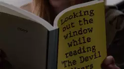 Looking out the window while reading 'The Devil Wears Prada' meme