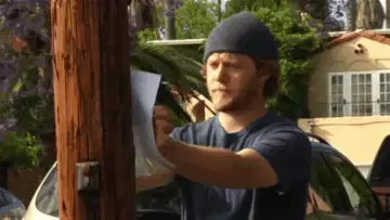 Man Tries Stapling Paper to Pole  