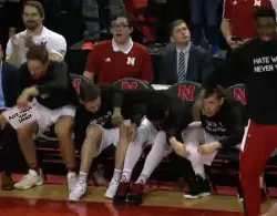 Basketball Players Raise Signs On Bench 