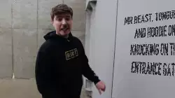 Mr Beast, tongue out and hoodie on, knocking on the entrance gate meme