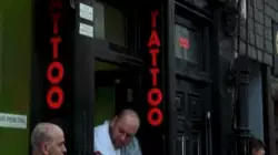 Man Looks At Arm Tattoo 