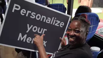 Woman Points to Sign on Bus 
